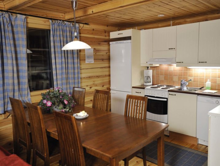 Mustikka-mökin tupakeittiö kuuden hengen ruokapöydällä.