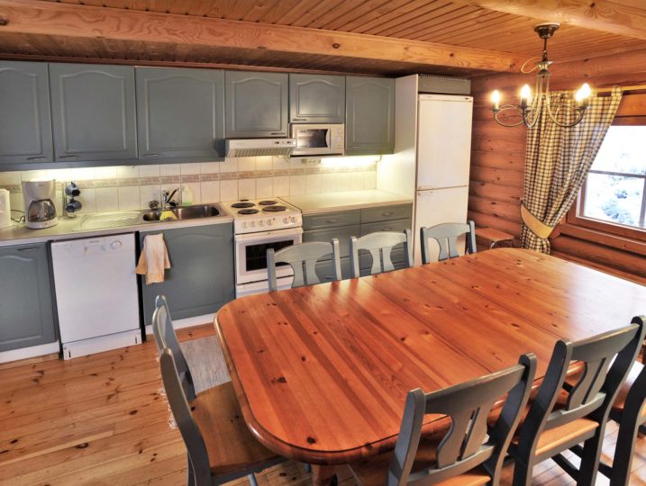 Oravanpesän keittiö kahdeksan hengen ruokapöydällä.