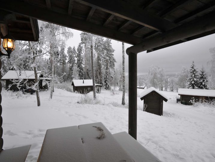 Näkymä Ukko-torpan kuistilta mäkeen jossa sijaitsee viisi samanlaista mökkiä, välimatka toisistaan n.30metriä.